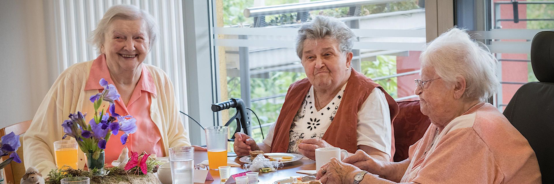 Foto: Mehrere Kinder halten ein DRK-Banner und blicken lachend in die Kamera.